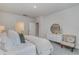 Stylishly staged bedroom with white linens and a comfortable sitting chair and view of the bathroom at 501 Haven View Way, Murrells Inlet, SC 29576