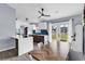 Dining room with wood table, white chairs, and an open concept view of the modern kitchen at 5031 Medieval Dr., Conway, SC 29526