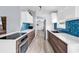 Contemporary kitchen showcasing stylish blue backsplash, wood cabinets, and sleek countertops at 5031 Medieval Dr., Conway, SC 29526