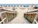 Direct beach access with stairs leading down to the sandy shore with beach umbrellas at 504 N Ocean Blvd. # 1106, Myrtle Beach, SC 29577