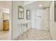 Bright condo entryway features tile flooring, mirrored table, artwork, and bathroom at 504 N Ocean Blvd. # 1106, Myrtle Beach, SC 29577