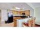 The kitchen offers black appliances and a breakfast bar with three red chairs at 504 N Ocean Blvd. # 1106, Myrtle Beach, SC 29577