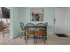 Dining table with seating for four, complemented by artwork and nearby exit at 5409 N Ocean Blvd. # 100, North Myrtle Beach, SC 29582