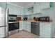 Cozy kitchen with stainless steel appliances and light blue cabinetry at 5409 N Ocean Blvd. # 100, North Myrtle Beach, SC 29582