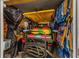 Organized garage featuring a golf cart with colorful seats and neatly stored beach chairs at 6001 - 1082 S Kings Hwy., Myrtle Beach, SC 29575