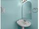 Charming bathroom with a pedestal sink, rounded mirror, and light blue walls, offering a clean and fresh feel at 6001-1808 S Kings Hwy., Myrtle Beach, SC 29575