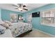 Cozy bedroom with blue walls, a colorful comforter, and ample natural light, creating a serene retreat at 6001-1808 S Kings Hwy., Myrtle Beach, SC 29575