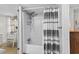 Clean bathroom features a shower-tub, a gray-and-white striped shower curtain and wall art at 6001-T3 S Kings Hwy., Myrtle Beach, SC 29575