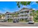 A beautiful three-story condo building with palm trees and a well-maintained parking lot at 6015 Catalina Dr. # 732, North Myrtle Beach, SC 29582