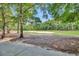 Scenic view of a lush green golf course with mature trees and a pristine sand trap under a blue sky at 6015 Catalina Dr. # 732, North Myrtle Beach, SC 29582