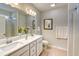 Bathroom with double sinks, white cabinets, light countertops, framed art and a shower with glass door at 631 Rycola Circle, Surfside Beach, SC 29575