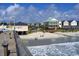 Picturesque beach view from a pier with beach homes, and gentle waves providing a serene coastal setting at 631 Rycola Circle, Surfside Beach, SC 29575