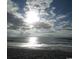Calm beach scene with clear skies, gentle waves and sand reflecting sunlight, creating a serene view at 631 Rycola Circle, Surfside Beach, SC 29575