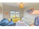 Bright bedroom featuring a window seat, blue sofa, a bed with patterned quilt and decorative accents at 631 Rycola Circle, Surfside Beach, SC 29575