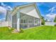 Relaxing screened porch showcasing comfortable seating, ideal for enjoying the outdoors, overlooking large backyard with lush green grass at 631 Rycola Circle, Surfside Beach, SC 29575