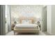 Comfortable bedroom featuring a plush bed with decorative pillows, neutral-toned wallpaper, and matching side tables at 6362 Swainson Street Sw, Ocean Isle Beach, NC 28469