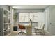 Modern home office space including a desk, comfortable seating, sleek shelving unit, and decorative artwork at 6362 Swainson Street Sw, Ocean Isle Beach, NC 28469