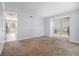Open living room with neutral carpet, large windows for natural light and sliding doors leading to an outdoor balcony at 6702 Jefferson Pl. # C6, Myrtle Beach, SC 29572