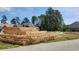 View of lumber piles at a residential construction site surrounded by wooded area at 800 Stone Pine Ct., Loris, SC 29569