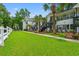 Charming condo exteriors surrounded by lush green lawns and mature palm trees at 820 Fairway Dr. # 1502Hh, Longs, SC 29568