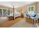 Spacious bedroom boasts a sitting area, four-poster bed, and access to a private balcony at 95 Sanderling Ave., Georgetown, SC 29440