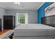 Bright bedroom with a black bed frame and nightstand, complemented by a blue accent wall and natural light at 100 Lazy Willow Ln. # 103, Myrtle Beach, SC 29588