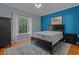 Bright bedroom with a black bed frame and nightstand, complemented by a blue accent wall and natural light at 100 Lazy Willow Ln. # 103, Myrtle Beach, SC 29588