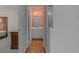 Hallway view into a bathroom with an orange wall, white vanity, and wood-look flooring at 100 Lazy Willow Ln. # 103, Myrtle Beach, SC 29588