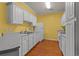 Well-lit kitchen with white cabinets, gray countertops, and wood-look flooring at 100 Lazy Willow Ln. # 103, Myrtle Beach, SC 29588