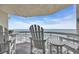 Balcony with comfortable white Adirondack chairs offering stunning ocean views at 1012 N Waccamaw Dr. # 1107, Murrells Inlet, SC 29576
