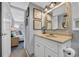 Bathroom features a decorative mirror over a vanity, complemented by coastal wall art, leading to a glimpse of the adjacent bedroom at 1012 N Waccamaw Dr. # 1107, Murrells Inlet, SC 29576