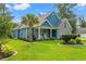 Charming home featuring a well-manicured lawn and complemented by a lush palm tree, offering curb appeal at 1051 Academy Dr., Conway, SC 29526
