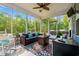 Inviting screened porch with cozy seating, ceiling fan, and serene wooded views at 1051 Academy Dr., Conway, SC 29526