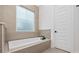Contemporary bathtub with tiled surround, frosted window, and modern fixtures at 1058 East Isle Of Palms Ave., Myrtle Beach, SC 29579