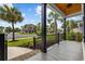 Inviting front porch view with black metal railings, palm trees and neatly landscaped yard at 1058 East Isle Of Palms Ave., Myrtle Beach, SC 29579