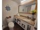 Well-lit bathroom with a granite countertop, vanity, decorative accents, and a toilet at 1207 S Ocean Blvd. # 20806, Myrtle Beach, SC 29577
