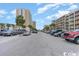 Parking lot and street view with multiple vehicles parked in a coastal setting near palm trees at 1207 S Ocean Blvd. # 20806, Myrtle Beach, SC 29577