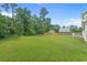 Expansive, well-maintained backyard with lush green grass, mature trees and fenced in backyard at 124 Wicklow Way, Pawleys Island, SC 29585