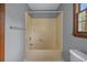 Bathroom showcasing a bathtub with tile surround, complemented by a window at 124 Wicklow Way, Pawleys Island, SC 29585