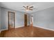 Open bedroom view with ceiling fan, hardwood floors, and doors leading to other rooms at 124 Wicklow Way, Pawleys Island, SC 29585