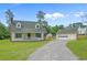 Charming two-story home with yellow siding, a white porch, and a detached garage on a large lot at 124 Wicklow Way, Pawleys Island, SC 29585