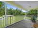 Relaxing covered porch featuring wood floors, a classic rocking chair, and views of the well-manicured lawn at 124 Wicklow Way, Pawleys Island, SC 29585