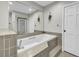 Relaxing bathroom features a built-in tub with gray tile and large mirror, next to a door at 1305 Forest View Rd., Conway, SC 29526