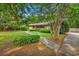Quaint front yard features trimmed green shrubs, sidewalk, grass and mature trees at 1305 Forest View Rd., Conway, SC 29526