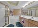 Bright bathroom with a glass shower, bathtub, double vanity, and ornate sconces at 145 South Dunes Dr. # 308, Pawleys Island, SC 29585