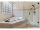 Bathroom featuring a large tub, glass shower, neutral tile and glass block window at 1501 Harbor Dr., North Myrtle Beach, SC 29582
