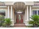 Elegant front entrance showcasing a decorative door, columns, an arched portico, and lush landscaping at 1501 Harbor Dr., North Myrtle Beach, SC 29582