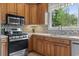 Open kitchen featuring stainless steel appliances, wood cabinets, and a view out to the yard at 1501 Harbor Dr., North Myrtle Beach, SC 29582