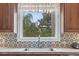 Bright kitchen window with a lovely view and backsplash behind a stainless steel sink at 1501 Harbor Dr., North Myrtle Beach, SC 29582