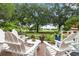 Charming outdoor patio area featuring white Adirondack chairs, a small table, and beautiful landscaping at 1501 Harbor Dr., North Myrtle Beach, SC 29582
